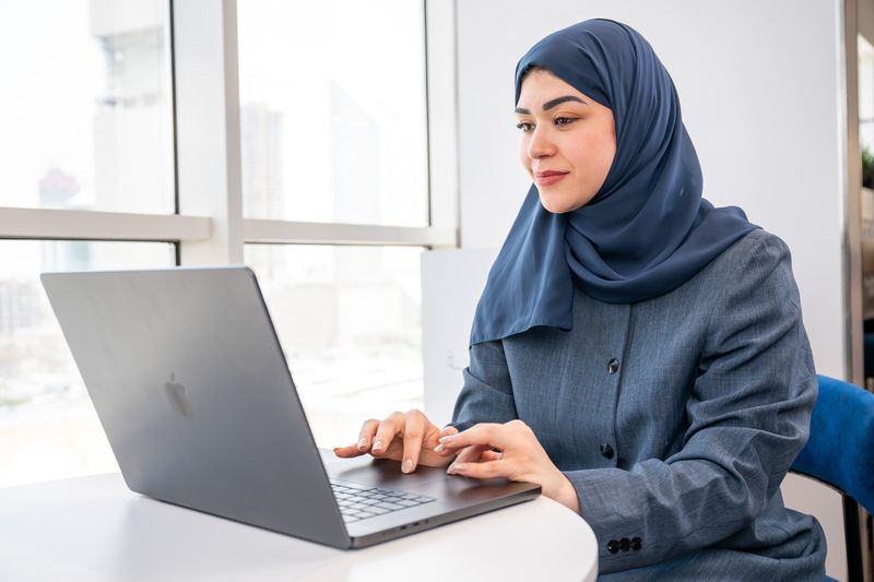 طالبة تعمل على حاسوب محمول